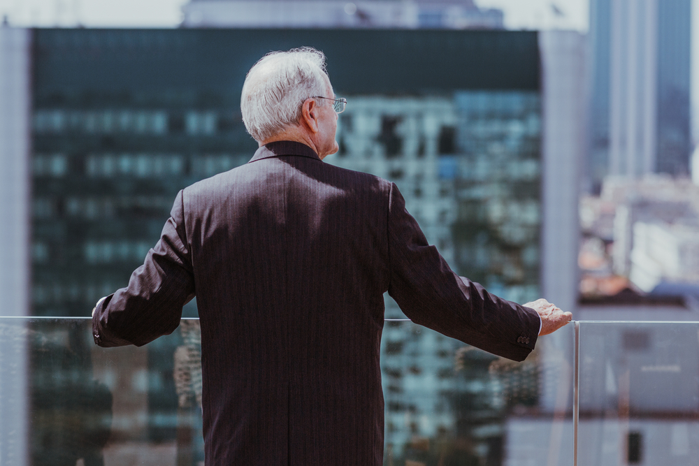 Senior man on a balcony overlooking the city