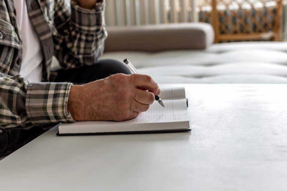 Senior man writing in a notebook