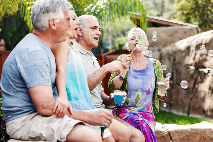 Group of seniors blowing bubbles outside