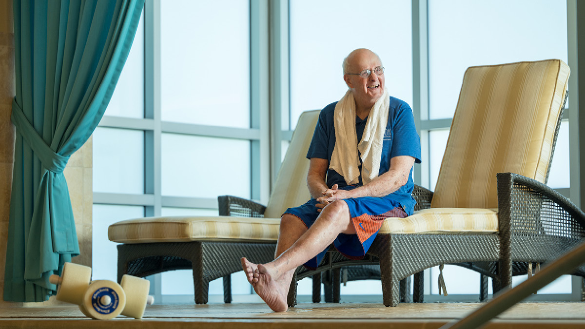 man sitting on chair at swimming pool