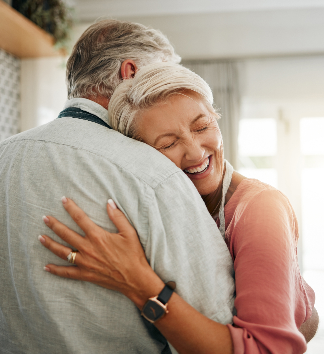A senior woman hugs her husband