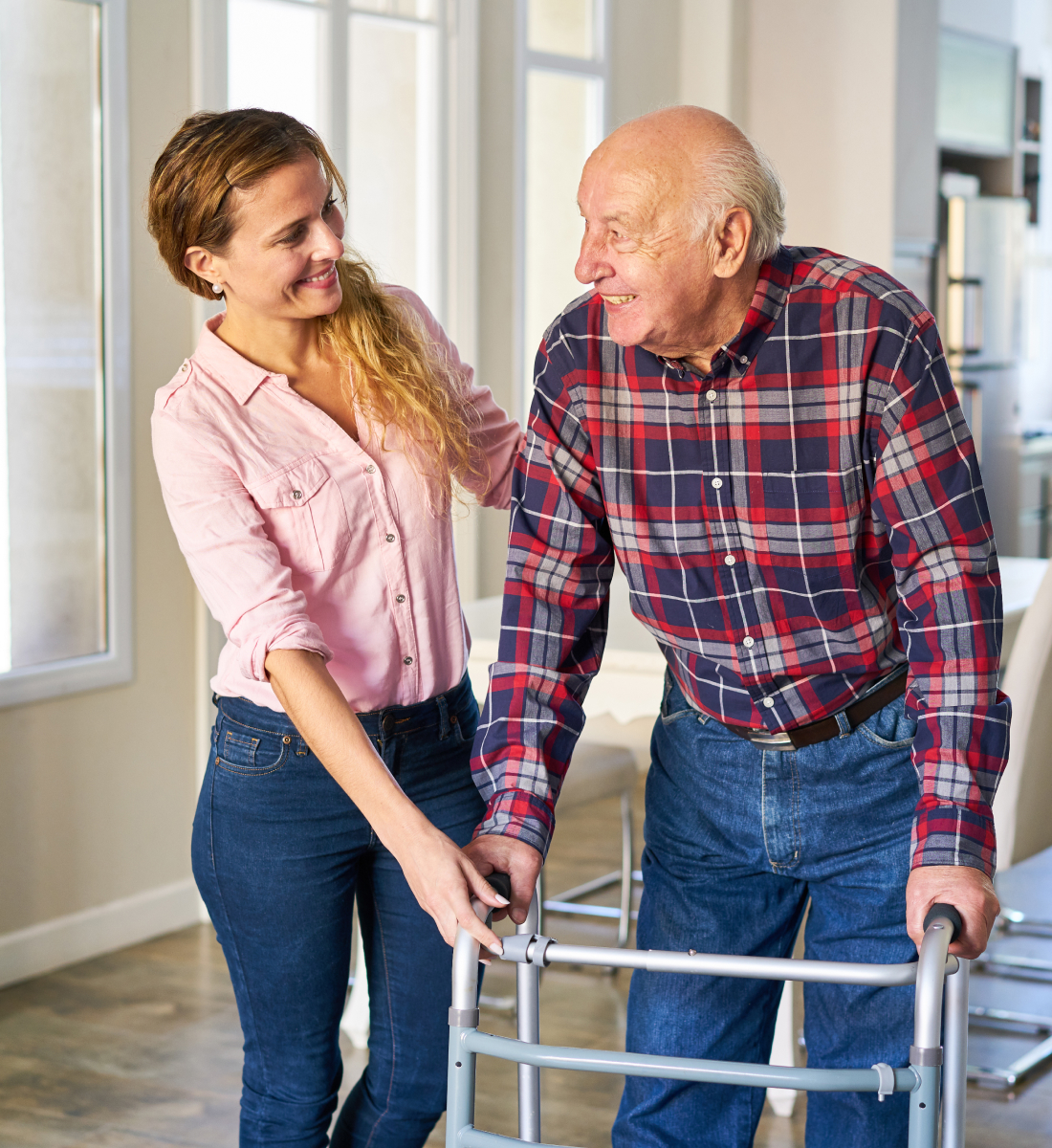 A woman helps an elderly man with his walker