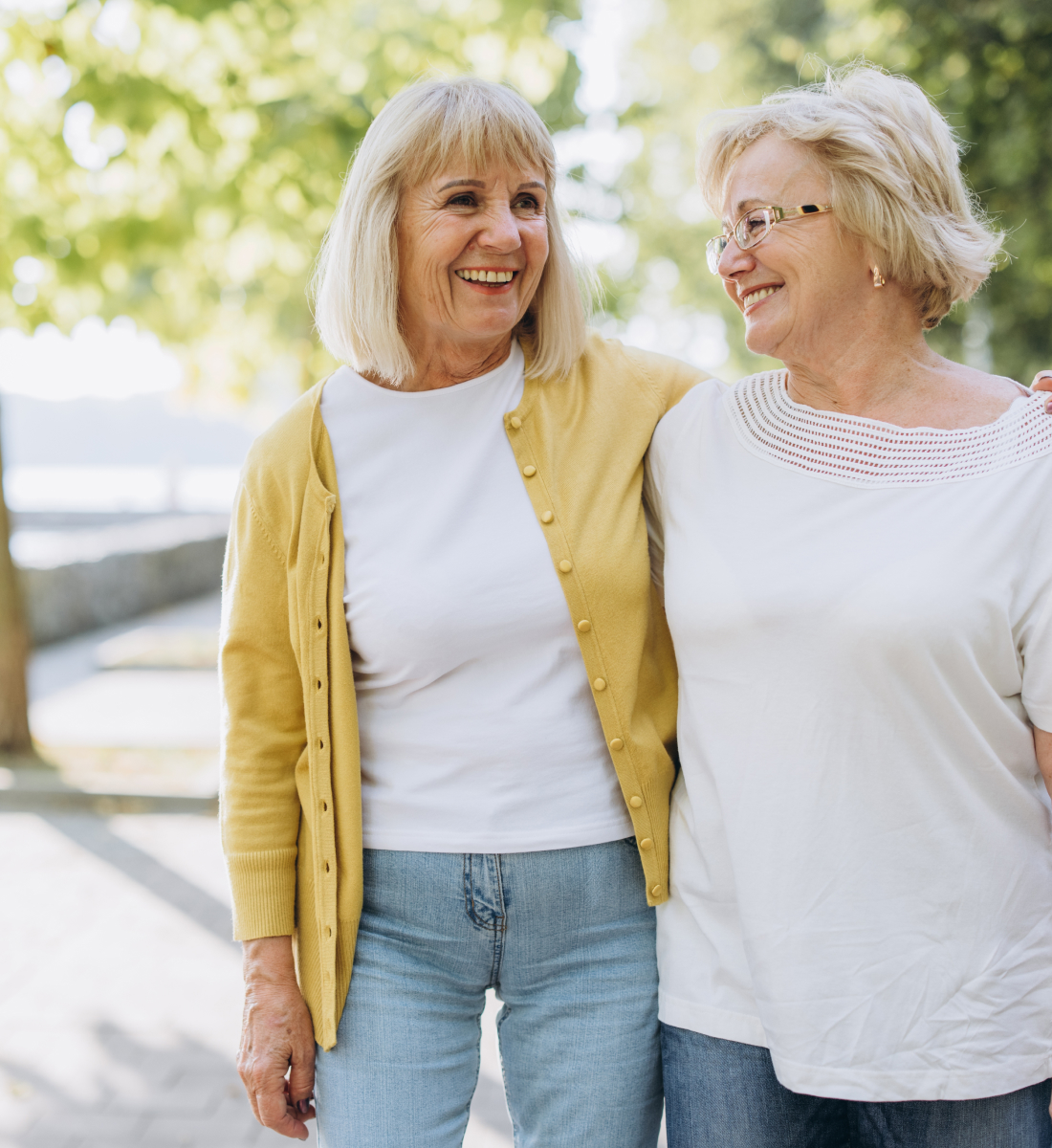 Two older women smile and walk side by side