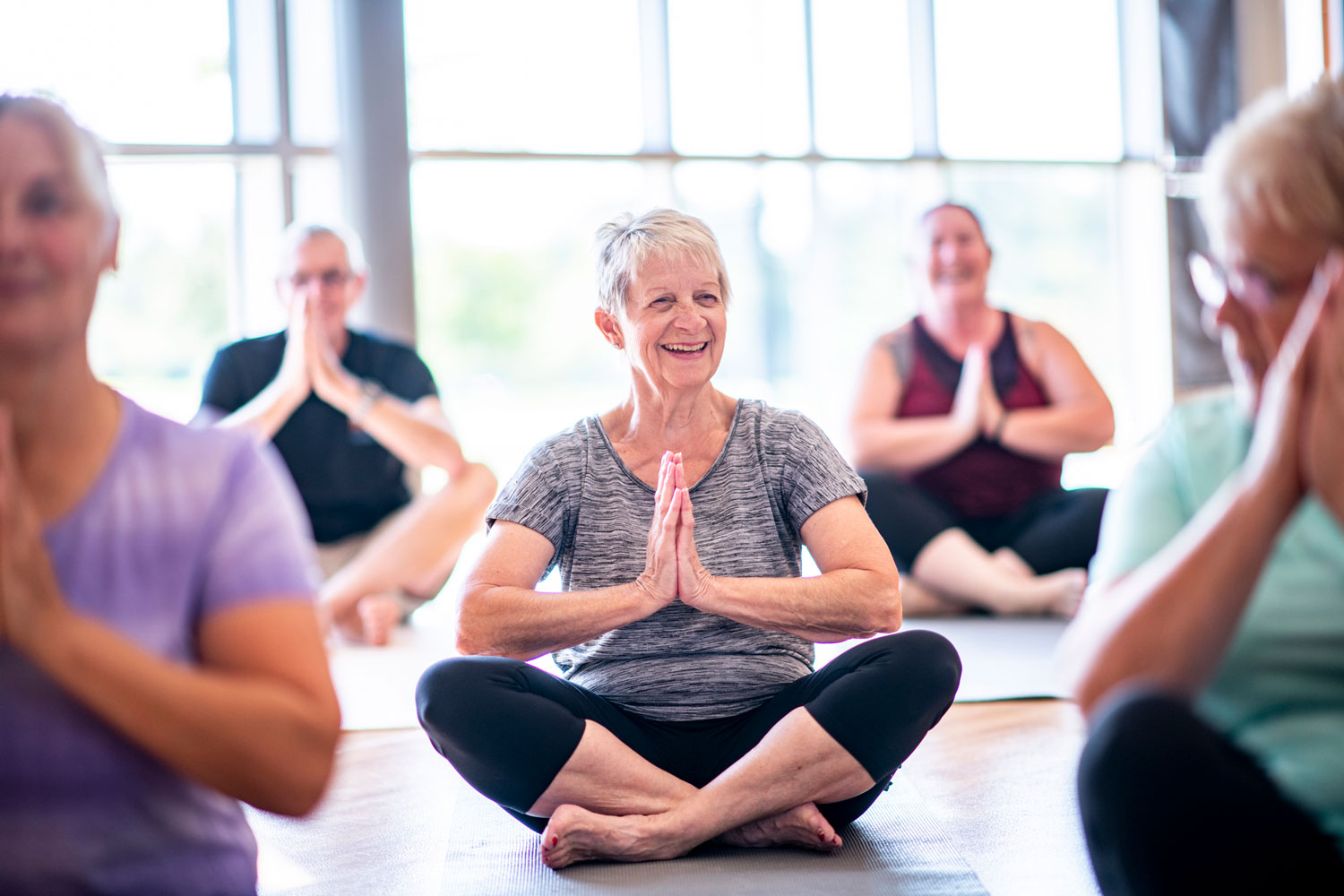 a group of seniors taking a yoga class at their senior living community