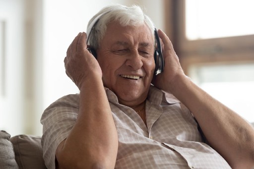 senior man enjoying music he's listening to in his senior apartment