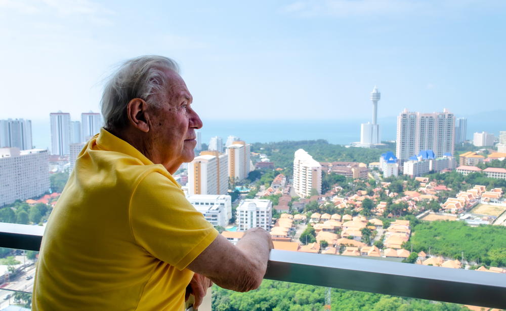 Senior man overlooking the city on a balcony