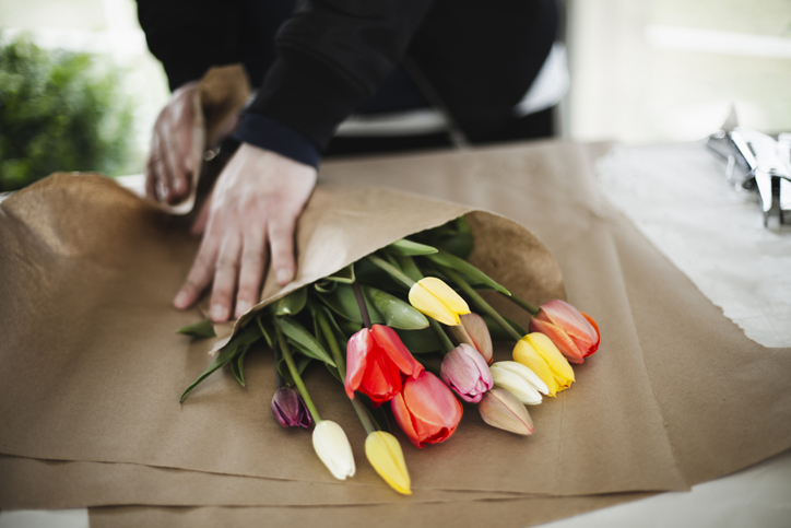closeup of a person rolling a bouquet of tulips