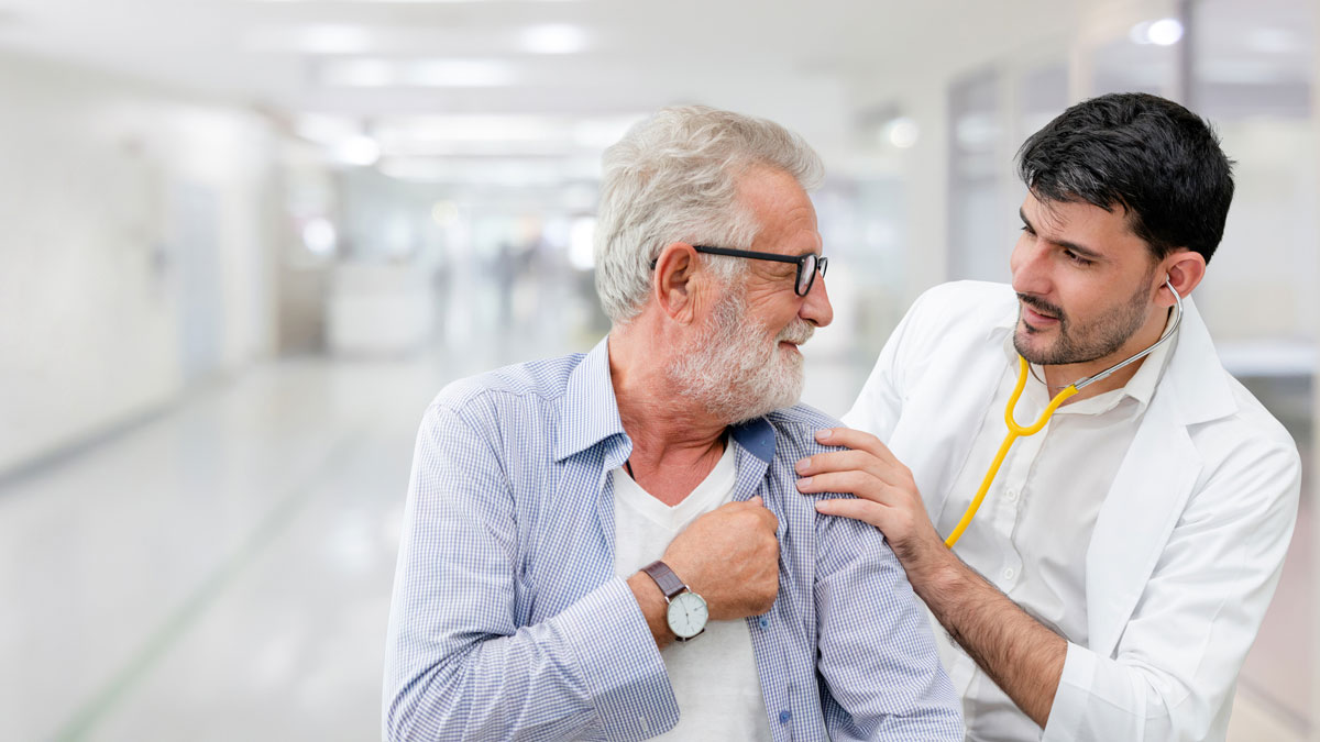An elderly man receiving a checkup from a doctor