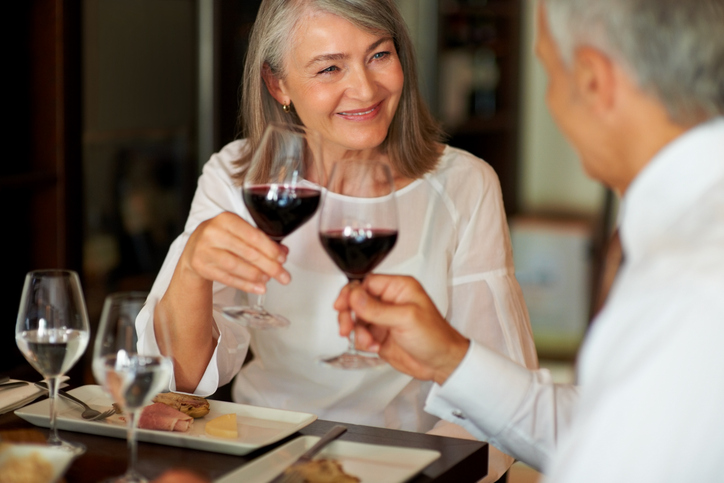 Woman happily sharing wine over dinner with her date.